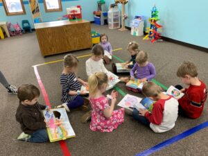 Photo of children ages 2 through 5 in the Sprouts room reading their bibles