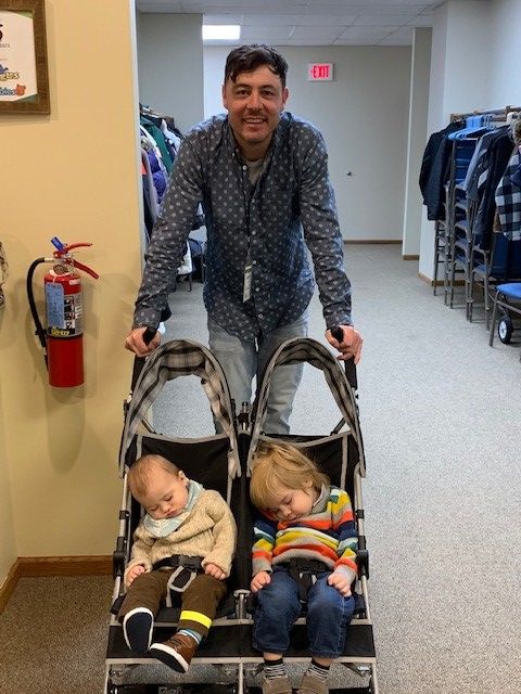Appleton Community EFC Children's Ministry volunteer walks in the hallways with two Lil Sprouts